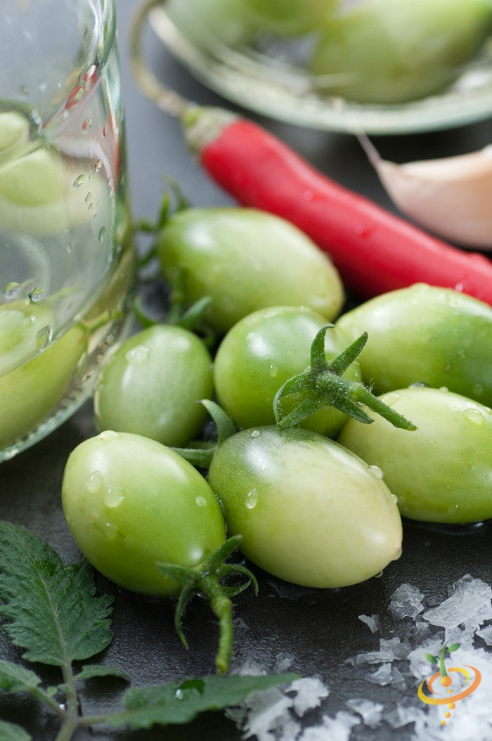 Green Grape Tomato seeds from SeedsNow, indeterminate variety, showing vibrant green grape-shaped tomatoes on the vine.